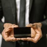 Close-up of a businessman holding a blank credit card with both hands, emphasizing finance.