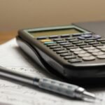 a calculator and a pen sitting on top of a piece of paper